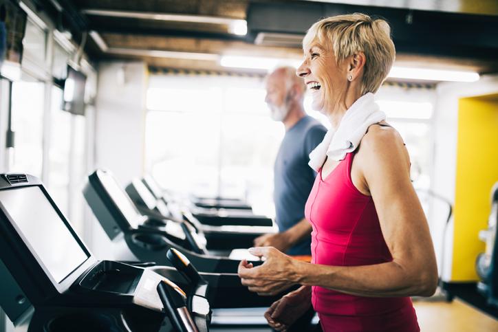 Elderly man and lady running on treadmill